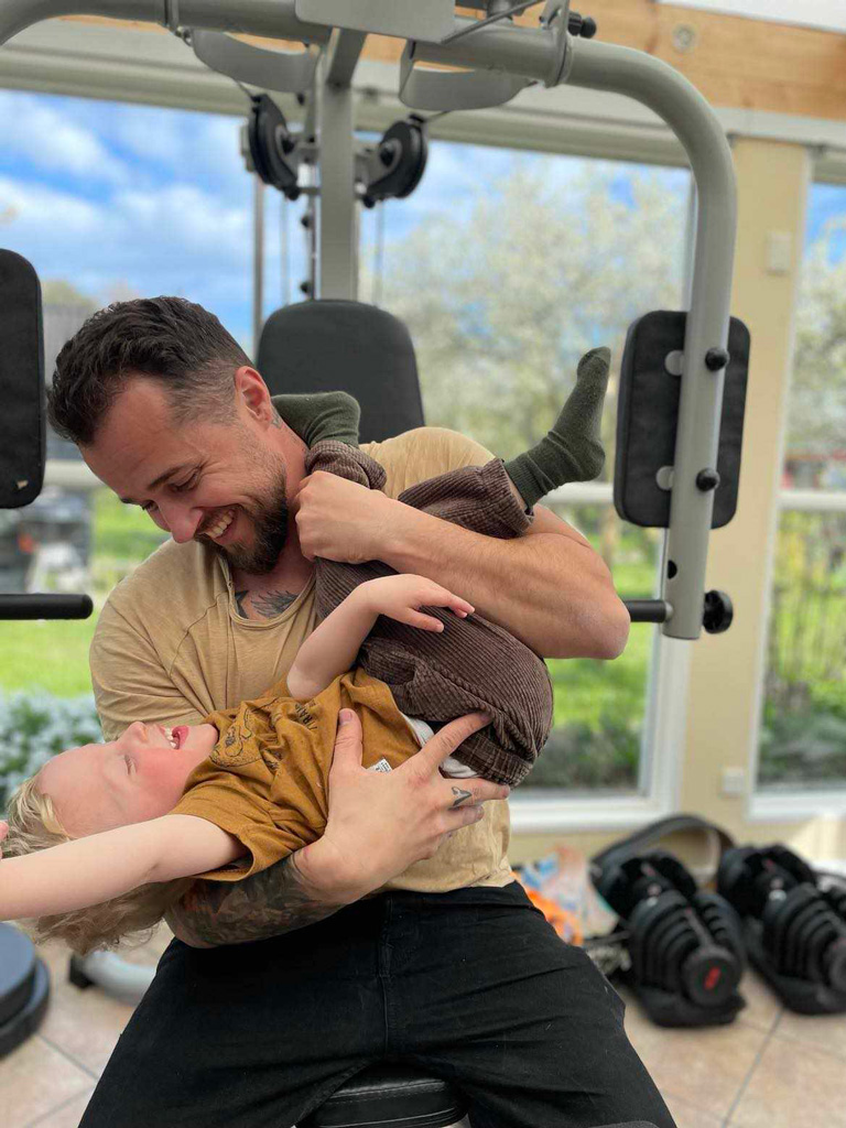 Træner med sin søn, mens han træner i fitnesscenteret.